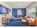 Bright living room with blue accent wall, modern furniture, and large windows with natural light at 237 Paisley Way, Locust Grove, GA 30248