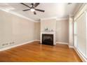 Bright living room featuring hardwood floors, a fireplace, ceiling fan, and large windows at 2551 Village Creek Se Lndg, Atlanta, GA 30316