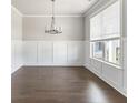 Bright living room featuring hardwood floors, wainscoting and a large window at 3926 Lockaby Way, Lawrenceville, GA 30044