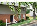 Townhouse exterior featuring brick accents, siding, and a welcoming entrance with a small, landscaped garden at 7750 Roswell Rd # 3D, Atlanta, GA 30350