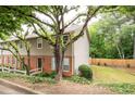 Exterior view of a well-maintained townhouse with brick and siding, surrounded by lush greenery and trees at 7750 Roswell Rd # 3D, Atlanta, GA 30350