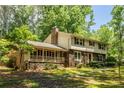Two-story home with stone accents, a covered porch, and a lush green lawn and mature trees at 5410 Rosser Rd, Stone Mountain, GA 30087