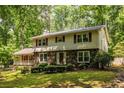 Attractive home featuring stone accents, a covered porch, beautiful landscaping and mature trees at 5410 Rosser Rd, Stone Mountain, GA 30087