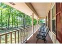 Relaxing covered porch with seating, offering a serene view of the surrounding trees and landscaped yard at 5410 Rosser Rd, Stone Mountain, GA 30087