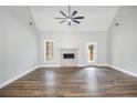 Bright living room features a ceiling fan, fireplace, wood floors, and natural light at 108 Deer Creek Run, Moreland, GA 30259