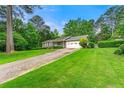 Traditional home with driveway and attached garage surrounded by lawn at 57 Fair Oaks Se Dr, Conyers, GA 30094