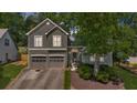 Charming two-story home features a two-car garage, arched entryway, and beautifully landscaped front yard at 1359 Chatley Way, Woodstock, GA 30188