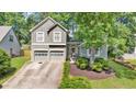 Charming two-story home features a two-car garage, arched entryway, and beautifully landscaped front yard at 1359 Chatley Way, Woodstock, GA 30188