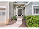 Elegant front entry with an arched window above the door, complemented by well-maintained landscaping at 1359 Chatley Way, Woodstock, GA 30188