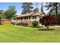 A ranch-style home with a brick foundation, covered porch, and well-manicured lawn and landscaping at 3802 Birchbriar Ct, Decatur, GA 30034