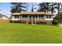 Ranch-style home featuring a brick foundation, covered porch, and a large, well-maintained lawn at 3802 Birchbriar Ct, Decatur, GA 30034