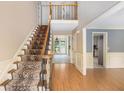 Bright foyer with hardwood floors, a carpeted staircase, and views into the home's living spaces at 106 Waterford Place Pl, Acworth, GA 30101