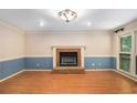 Spacious living room featuring a cozy fireplace, hardwood floors, and large windows at 106 Waterford Place Pl, Acworth, GA 30101