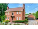 Beautiful two-story brick home with a detached garage and lush green landscaping at 110 Amsterdam Dr, Lilburn, GA 30047