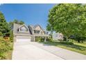 Beautiful two story brick home with a long driveway and a well-manicured lawn on a sunny day at 2304 Mitford Ct, Dacula, GA 30019
