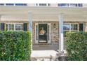 Inviting front porch with brick columns, black shutters, and a charming front door at 2304 Mitford Ct, Dacula, GA 30019