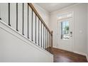 Bright foyer features a staircase with decorative black metal spindles and hardwood floors at 80 Hampton Ter, Dallas, GA 30157