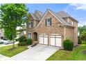 Beautiful brick home featuring a two-car garage and lush green landscaping at 4677 Prater Se Way, Smyrna, GA 30080