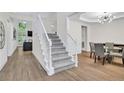 Bright foyer featuring hardwood floors, a staircase, and views into the living room and dining area at 870 River Cliff Ct, Suwanee, GA 30024