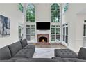 Two-story living room with large windows, brick fireplace and lots of natural light at 870 River Cliff Ct, Suwanee, GA 30024