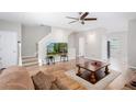 Inviting living room with wood floors, a ceiling fan, and a staircase leading to the upper level at 1122 Cotton Gin Dr, Woodstock, GA 30188