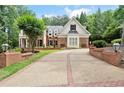 Beautiful two-story brick home with manicured landscaping and a long driveway at 311 Rolling Rock Se Rd, Marietta, GA 30067