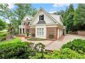 Stunning two-story brick home with an attached garage and manicured landscaping in a suburban neighborhood at 311 Rolling Rock Se Rd, Marietta, GA 30067