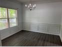Elegant dining room featuring dark wood-look floors, chair rail, and a modern chandelier at 519 Granite Nw Ct, Lawrenceville, GA 30044
