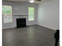 Comfortable living room featuring dark wood-look flooring, a fireplace, and lots of natural light at 519 Granite Nw Ct, Lawrenceville, GA 30044