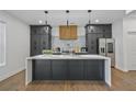 A contemporary kitchen featuring dark cabinetry, a modern island, and stainless steel appliances at 2809 Glenwood Se Ave, Atlanta, GA 30317