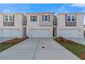 New townhomes with garage, grey accents, landscaping, and symmetrical design under clear sky at 321 Heavenly Hollow Pl, Mcdonough, GA 30253