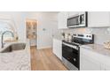 Bright kitchen with stainless steel appliances, white cabinets, granite countertops, and a pantry at 1888 Copelyn Reese Court (Lot 164), Lawrenceville, GA 30043