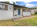 Close up of white brick home with welcoming front porch, blue door and wood columns at 2677 Tilson Rd, Decatur, GA 30032