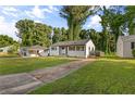 Charming white brick home with long driveway and grassy front yard with mature trees at 2677 Tilson Rd, Decatur, GA 30032