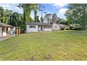View of a one-story home with white painted brick and a green lawn, and other homes nearby at 2677 Tilson Rd, Decatur, GA 30032