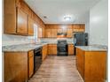 Well-lit kitchen with wood cabinets, sleek countertops, and modern black appliances at 1934 Patton Pl, Lithonia, GA 30058