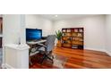 Home office area featuring hardwood floors, a built-in bookcase, and an executive desk at 2624 Lake Erin Drive Dr, Tucker, GA 30084