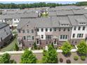 An aerial view of townhomes featuring brick facades, covered entries, balconies, and manicured landscaping at 416 Montclair Ct, Woodstock, GA 30188