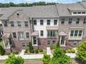 Charming townhome featuring a brick facade, covered entry, balcony, and professionally landscaped front yard at 416 Montclair Ct, Woodstock, GA 30188