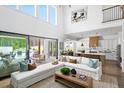 Spacious living room with high ceilings, a modern sofa, and sliding glass doors that lead to an outdoor patio at 6930 Pond View Dr, Cumming, GA 30028
