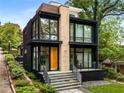 A modern two-story home with dark exterior, stone accents, large windows and a beautifully landscaped front yard at 819 Belgrade Ne Ave, Atlanta, GA 30306