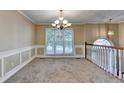 Elegant dining room boasting wainscoting, a chandelier, and large windows with a scenic view at 1400 Scenic Brook Sw Trl, Conyers, GA 30094