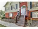 Inviting front entrance featuring a white door, brick accents, and wooden steps leading to the home at 1400 Scenic Brook Sw Trl, Conyers, GA 30094