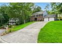 Classic two-story home with a long driveway and lush green lawn at 1911 Woodmont Ct, Marietta, GA 30062
