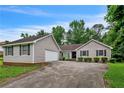 Single-story home with attached garage, concrete driveway and mature trees in the background at 3333 Old Salem Se Rd, Conyers, GA 30013