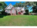 Beautiful brick house with well-manicured lawn and mature trees providing shade at 1595 Lake Lucerne Rd Sw, Lilburn, GA 30047