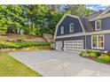 Spacious driveway leads to a three-car garage, surrounded by lush landscaping at 321 River Green Ave, Canton, GA 30114
