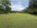 Expansive front yard of a single-story brick home surrounded by mature trees at 1856 Butler Bridge Rd, Covington, GA 30016