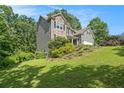 Attractive home with stone accents and gray siding, nestled on a gently sloping lawn with lush trees at 27 Rose Brooke Cir, White, GA 30184