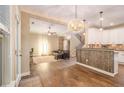 Open-concept living room featuring hardwood floors, a decorative light fixture, and seamless flow into the kitchen at 27 Rose Brooke Cir, White, GA 30184